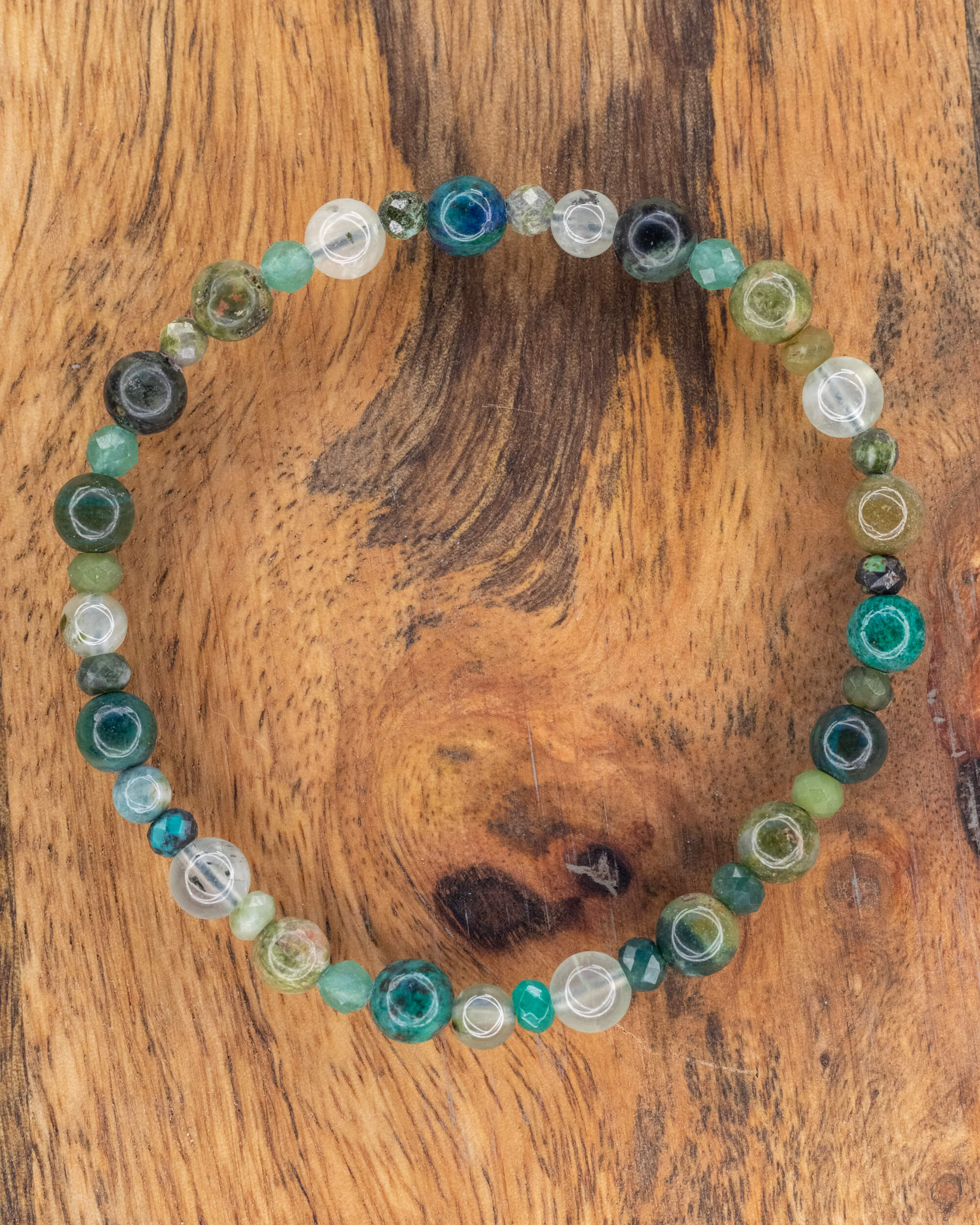 Pulsera Mix de Minerales Verdes, pieza completa en círculo sobre madera clara