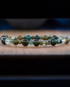 Pulsera Mix de Minerales Verdes puesta de perfil sobre superficie de madera