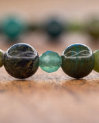 Detalle macro de cuentas facetadas y lisas verdes de la pulsera mix de minerales